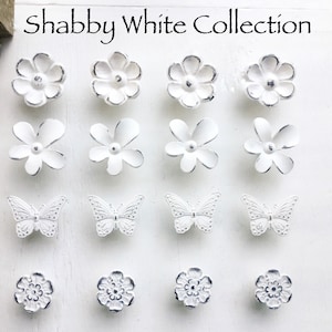 May include: Shabby White Collection of decorative drawer pulls featuring a variety of floral and butterfly designs. The pulls are all white and have a distressed finish.