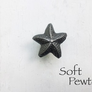 May include: A soft pewter starfish cabinet knob. The knob is a 3D starfish design with a textured surface.