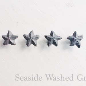 May include: Four gray ceramic starfish with a slightly textured surface. Seaside Washed Greys.