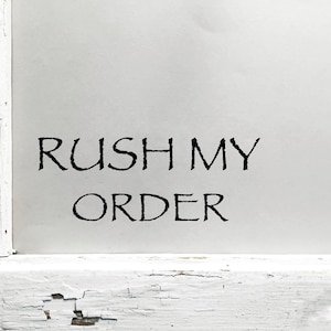 May include: White painted wood sign with black text that reads "Rush My Order".