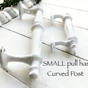 May include: Two white, distressed-finish cabinet pulls with a curved post design. The pulls are made of metal and have a vintage, farmhouse aesthetic. The text on the image says "SMALL pull has Curved Post".