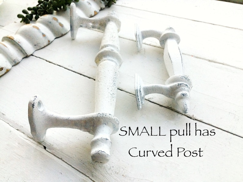 May include: Two white, distressed-finish cabinet pulls with a curved post design. The pulls are made of metal and have a vintage, farmhouse aesthetic. The text on the image says "SMALL pull has Curved Post".