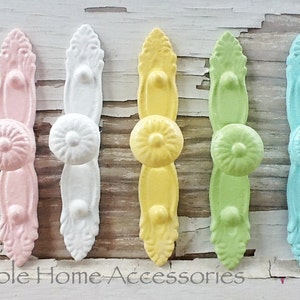 May include: Five decorative cabinet knobs in pastel colors. The knobs are made of metal and have a floral design. The colors are pink, white, yellow, green, and blue.
