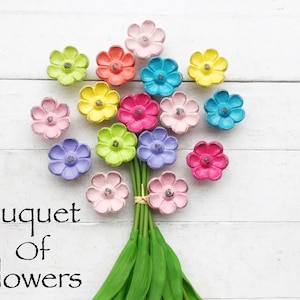 May include: A bouquet of colorful flowers made from painted wooden pieces. The flowers are arranged in a circle and have a rustic, vintage look. The text "Bouquet of Flowers" is written below the flowers.