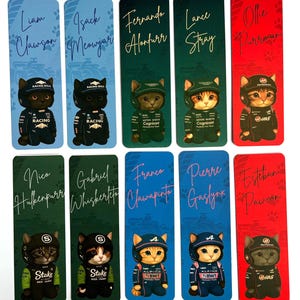 May include: A collection of ten rectangular bookmarks featuring cartoon cat illustrations dressed in racing attire. Each bookmark has a different name written in cursive, with paw prints at the top. The color scheme varies, including blue, green, and red backgrounds.