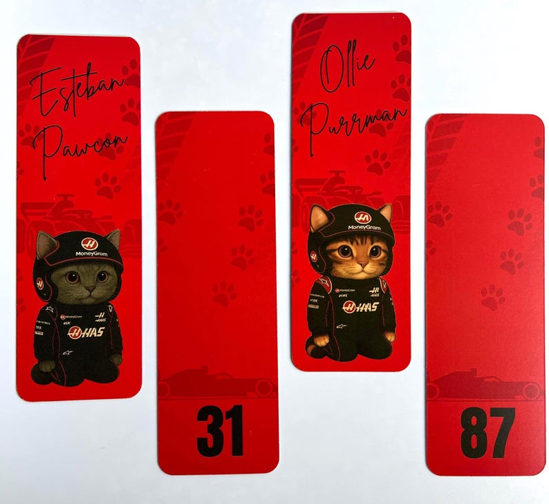 May include: Red bookmarks featuring a cartoon cat in a racing suit and helmet. The bookmarks have names like "Esteban Pawcon" and "Ollie Purrman", along with the numbers 31 and 87. Paw prints and race car silhouettes decorate the background.