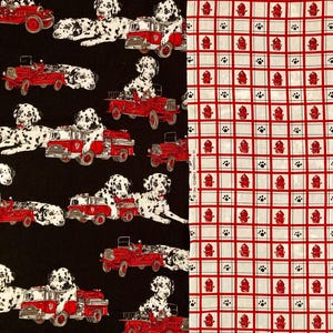 May include: Fabric with two distinct patterns. One side features Dalmatian dogs with red fire trucks on a black background. The other side has a white background with a red grid pattern, red fire hydrants, and paw prints.