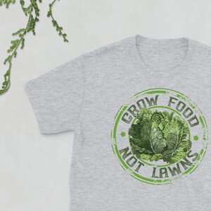 May include: A grey t-shirt with a green distressed circle graphic that says "Grow Food Not Lawns" with a picture of a head of lettuce inside the circle.