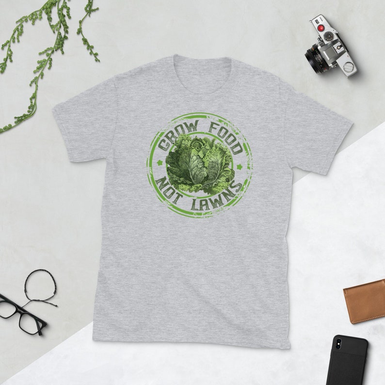 May include: A grey t-shirt with a green distressed circle graphic that says "Grow Food Not Lawns" with a picture of a head of lettuce inside the circle.
