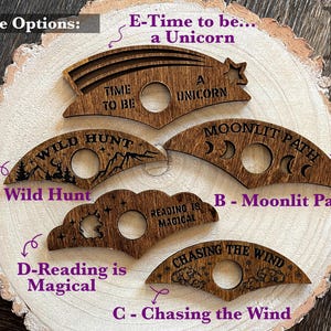 May include: Five wooden cutouts with different designs and text. The designs include a crescent moon, a cloud, a unicorn, a mountain range, and a star. The text includes "Time to be a Unicorn", "Wild Hunt", "Moonlit Path", "Reading is Magical", and "Chasing the Wind".