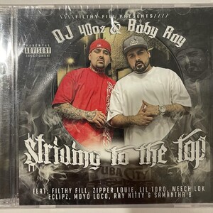 May include: CD case featuring two men, DJ 40oz and Baby Ray, with the title "Striving to the Top." The cover has a dark background with smoke effects and the text "Parental Advisory Explicit Content."
