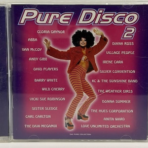 May include: A CD case for "Pure Disco 2" featuring a woman in a red jacket and striped pants. The cover is purple and pink with the names of disco artists like ABBA, Diana Ross, and Donna Summer.