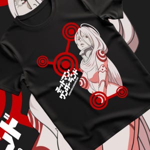 Peut inclure: T-shirt noir avec un motif d'un personnage d'anime féminin aux cheveux blancs et des accents rouges. Le design comprend du texte japonais et des cercles rouges. Un t-shirt à col rond.