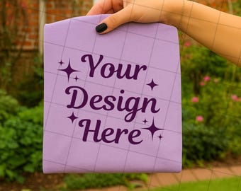 Maqueta de camiseta Violet Comfort Colors 1717: Mano sujetando una camiseta doblada (JPG y PNG)