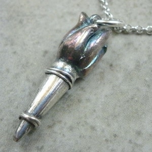 Op de afbeelding: Een zilveren toorts hanger ketting met een gedetailleerd vlamontwerp. De hanger is bevestigd aan een zilveren ketting.