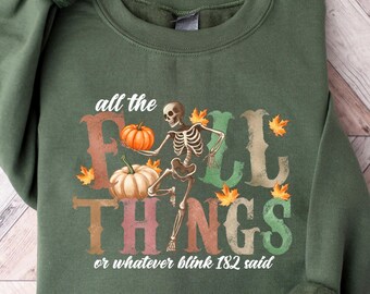 May include: Green sweatshirt with the text "all the FALL THINGS or whatever blink 182 said." The graphic includes a skeleton, pumpkins, and fall leaves. The sweatshirt is a solid green color.