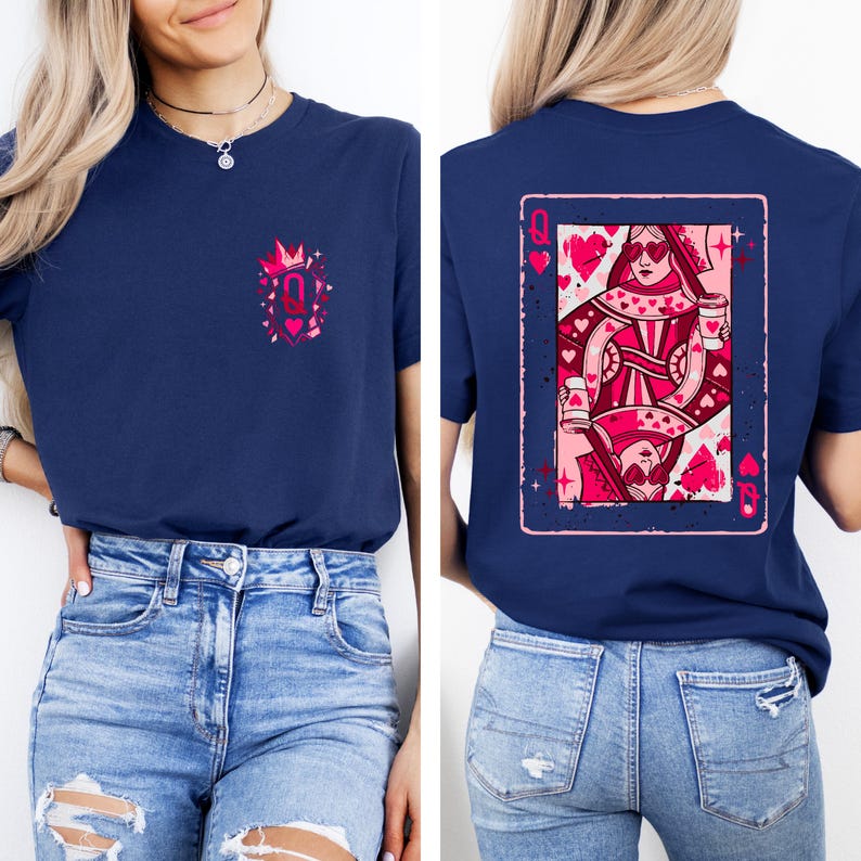 May include: Navy blue t-shirt featuring a pink and red Queen of Hearts playing card design on the back. The front of the shirt has a small pink graphic with a crown and the letter "Q". The shirt is paired with blue jeans.