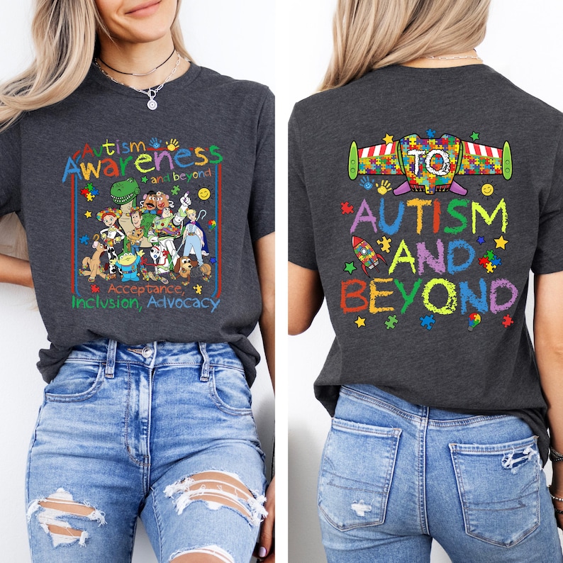 K&ouml;nnte beinhalten: Dunkelgraues T-Shirt mit einer farbenfrohen Grafik zur F&ouml;rderung des Autismus-Bewusstseins. Auf der Vorderseite stehen die Worte "Autismus Awareness and beyond" mit Zeichentrickfiguren. Auf der R&uuml;ckseite steht "Autism and Beyond" mit einer Rakete und Puzzleteilen.