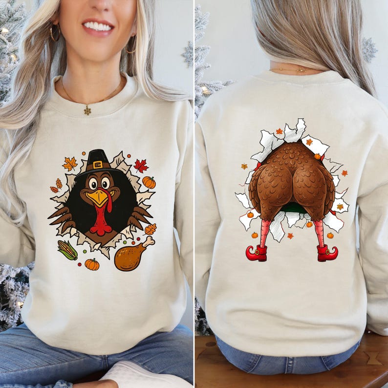 May include: Cream-colored sweatshirt featuring a cartoon turkey design. The front shows the turkey's head wearing a pilgrim hat, while the back displays the turkey's rear with red shoes. Thanksgiving-themed apparel.