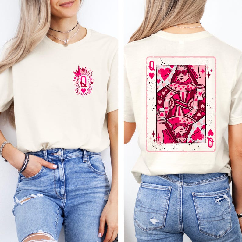May include: Cream-colored t-shirt featuring a pink Queen of Hearts playing card design on the back and a smaller matching design on the front. The card design includes hearts and the letter "Q". The shirt is made of a soft material.