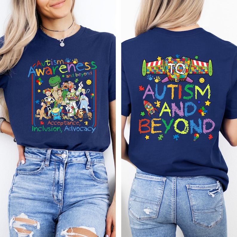 K&ouml;nnte beinhalten: Marineblaues T-Shirt mit den Worten "Autismus-Bewusstsein und dar&uuml;ber hinaus" in farbenfrohem Text. Die Vorderseite des Shirts zeigt eine Cartoon-Illustration verschiedener Charaktere. Auf der R&uuml;ckseite des Shirts stehen die Worte "Autismus und dar&uuml;ber hinaus" mit einer Raketen-Grafik.