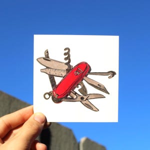May include: A drawing of a red Swiss Army knife with various tools extended, including a corkscrew, scissors, and a ruler. The knife is set against a bright blue sky background.
