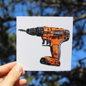 Pode incluir: Ilustração de uma furadeira sem fio laranja e preta em um quadrado branco. A broca é preta e se estende da frente da furadeira. O fundo está desfocado com tons de verde e azul.