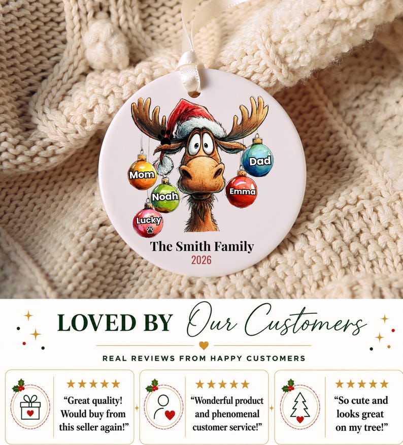 K&ouml;nnte beinhalten: Ein runder, wei&szlig;er Keramik-Weihnachtsanh&auml;nger mit einem Cartoon-Elch, der eine Weihnachtsm&uuml;tze tr&auml;gt. Der Elch ist von bunten Kugeln umgeben, die mit Mom, Noah, Lucky, Emma und Dad beschriftet sind. Der Text lautet The Smith Family und 2026.