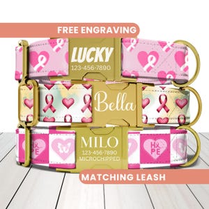 May include: Three personalized dog collars with gold buckles. The collars are pink and white, featuring heart and ribbon designs. Each collar has a name and phone number. The text "FREE ENGRAVING" and "MATCHING LEASH" are also visible.
