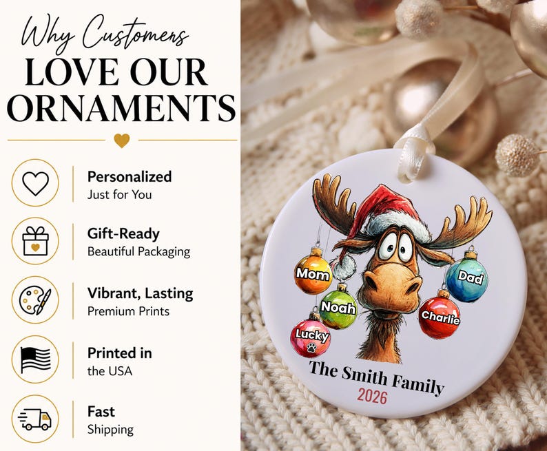 K&ouml;nnte beinhalten: Ein rundes, wei&szlig;es Keramikornament mit einem Cartoon-Elch, der eine Weihnachtsm&uuml;tze tr&auml;gt und bunte Weihnachtskugeln mit den Aufschriften Mom, Dad, Noah, Charlie und Lucky h&auml;lt. Der Text lautet The Smith Family und 2026. Ein wei&szlig;es Band.