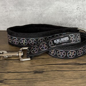 May include: Black dog collar and leash set with a repeating pentagram design in iridescent colors. The leash and collar have the text "REBELHOUND OBEY NO MASTER". The collar has a soft, black lining and a silver metal clasp.