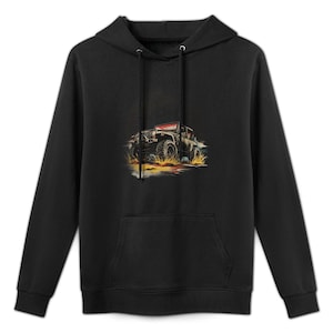 Puede incluir: Sudadera con capucha negra con bolsillo delantero y cordón. La sudadera presenta un gráfico de un vehículo todoterreno negro conduciendo por el agua, con detalles en amarillo y naranja.