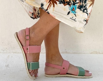 May include: Two-toned sandals with pink and green straps. The sandals have a simple design and a comfortable look.