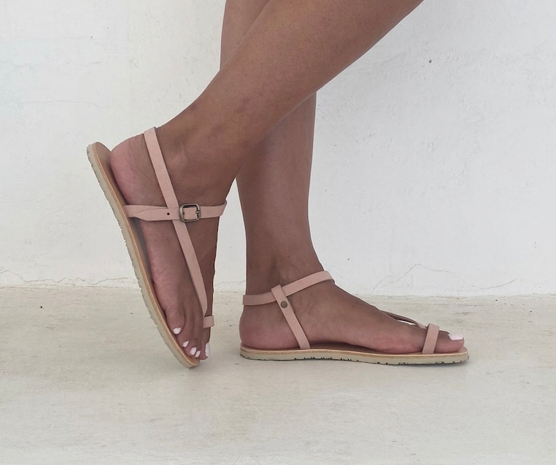Peut inclure: Une paire de sandales en cuir rose clair avec des brides &agrave; la cheville. Les sandales ont un design simple et sont parfaites pour l'&eacute;t&eacute;.
