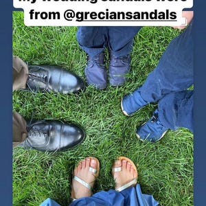 May include: A pair of silver metallic toe-ring sandals worn with a blue dress, surrounded by black leather dress shoes and blue casual shoes. The image includes the text: My wedding sandals were from @greciansandals and BAREFOOT WEDDING SHOES.