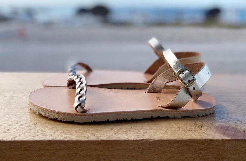 Side view of a gold handcrafted leather barefoot sandal on a neutral background, highlighting the zero-drop architecture and premium artisanal quality.