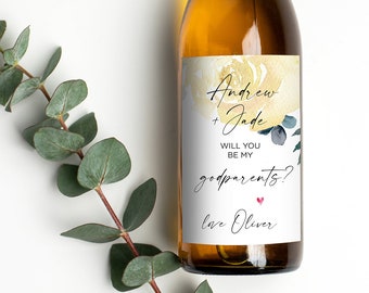 May include: A white wine bottle with a label that says "Andrew & Jade Will you be my godparents? Love Oliver" with a watercolor floral design in shades of blue and yellow.