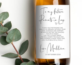 May include: A white wine bottle with a label that reads "To my future parents in law" with a handwritten message thanking them for raising the man of her dreams. The label also includes the date "23 September 2024" and the name "Love Mallison".