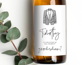 May include: A white wine bottle with a custom label that says "Timothy, It's time to suit up, will you be my groomsman?" with a black and white illustration of a suit and tie.