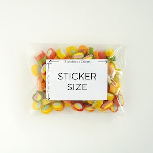 May include: A clear plastic bag filled with colorful candy. The bag is labeled "STICKER SIZE" with measurements of 3 inches (7.6 cm) by 2 inches (5 cm).