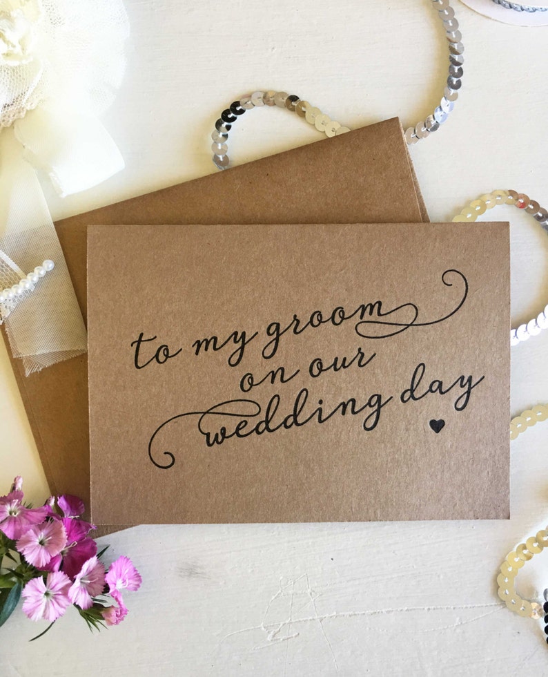May include: A brown card with the text "to my groom on our wedding day" in black script with a small heart.