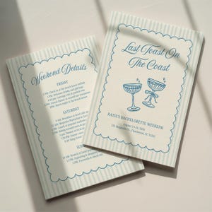 Könnte beinhalten: Zwei rechteckige Papierkarten mit hellblauen vertikalen Streifen und einem gewellten blauen Rand. Die Karten zeigen blauen Text, darunter 'Last Toast On The Coast', 'Weekend Details' und Zeitpläne für ein Bachelorette-Wochenende.