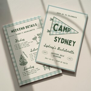 Peut inclure: Deux cartes d'invitation rectangulaires avec une bordure à carreaux vichy bleu clair et blanc. La carte du dessus indique JOIN US TO CELEBRATE CAMP SYDNEY, Sydney's Bachelorette, Jackson Hole Wyoming, July 23-25. La seconde liste les détails.