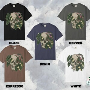 May include: Crew neck t-shirts in black, pepper, denim, espresso, and white. Each shirt features a skull design with green and pink leaves. The text "BLACK", "PEPPER", "DENIM", "ESPRESSO", and "WHITE" are displayed below each shirt.