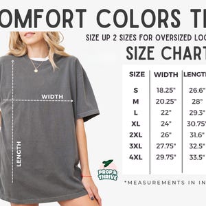May include: A gray Comfort Colors tee shirt with a size chart. The chart shows measurements in inches for sizes S to 4XL. The shirt is shown on a person, with the width and length measurements indicated.