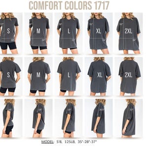 May include: A display of Comfort Colors 1717 t-shirts in various sizes, including S, M, L, XL, and 2XL. The shirts are a dark gray color and are shown on a model from multiple angles, with measurements in inches. The model is 5'8" and 125 lbs.