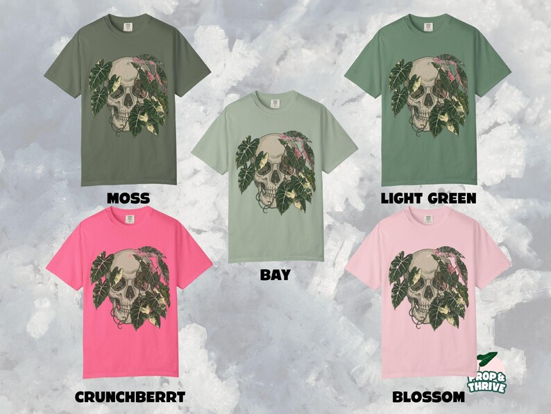 May include: Five short-sleeved t-shirts in various colors: moss, bay, light green, crunchberry, and blossom. Each shirt features a skull graphic with tropical leaves. The text "MOSS", "BAY", "LIGHT GREEN", "CRUNCHBERRY", and "BLOSSOM" are displayed.