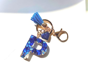 Llavero personalizado con inicial en resina azul y dije de corazón.
