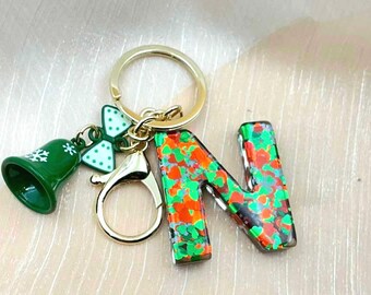 Llavero de resina con inicial navideña, dije de campana navideña, ideal para rellenar calcetines navideños.