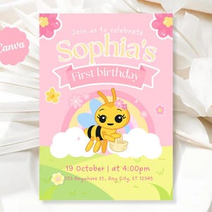 Puede incluir: Invitación de cumpleaños rosa y amarilla con una abeja de dibujos animados, un arcoíris y el texto "Sophia's First birthday". La invitación incluye la fecha, la hora y la dirección.